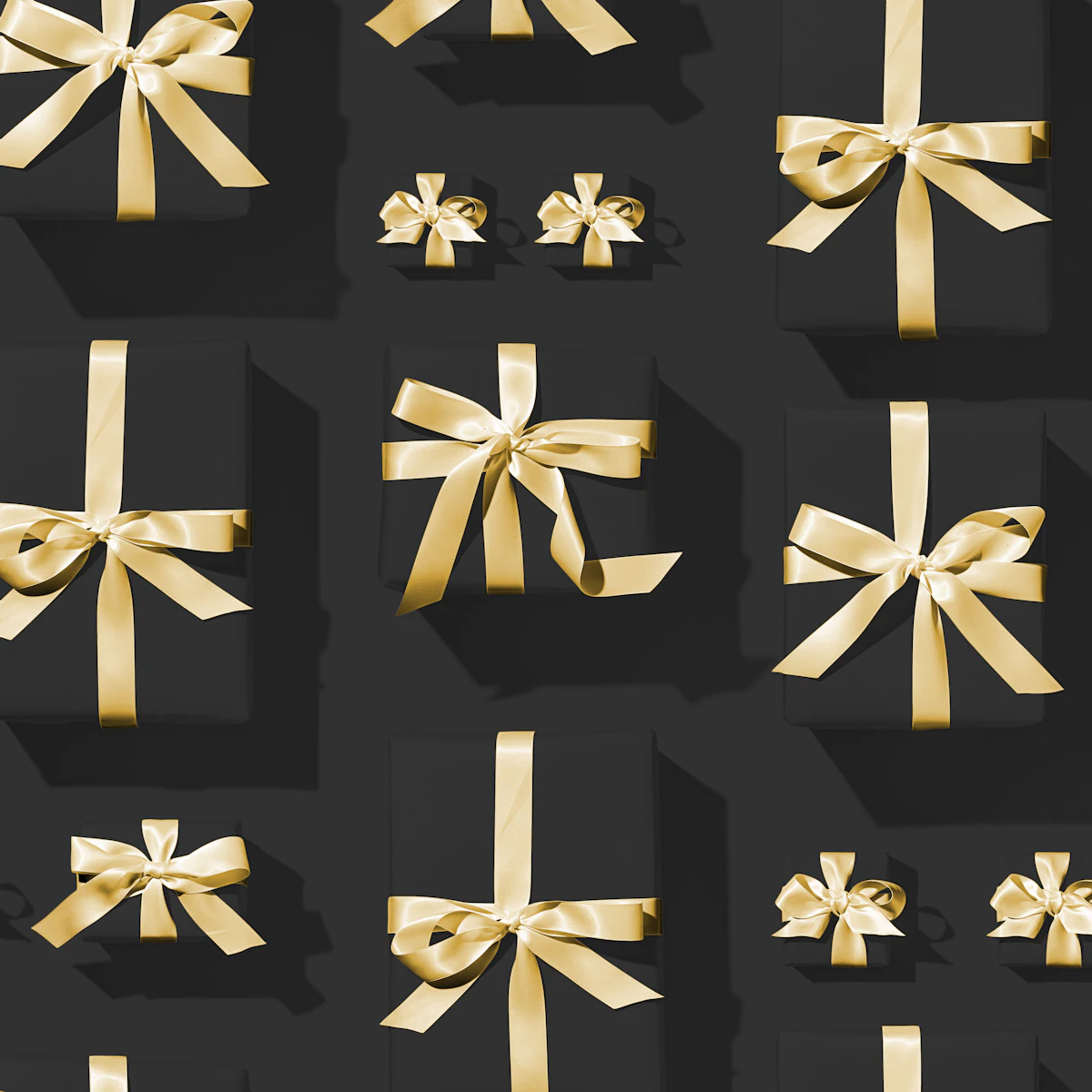 Gift boxes finished with gold satin bows, photographed from above